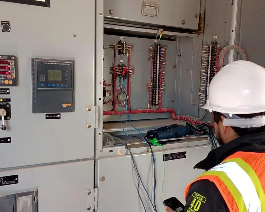 Ingeniero de GENEL midiendo parámetros eléctricos en un tablero de media tensión con un analizador de calidad de la energía