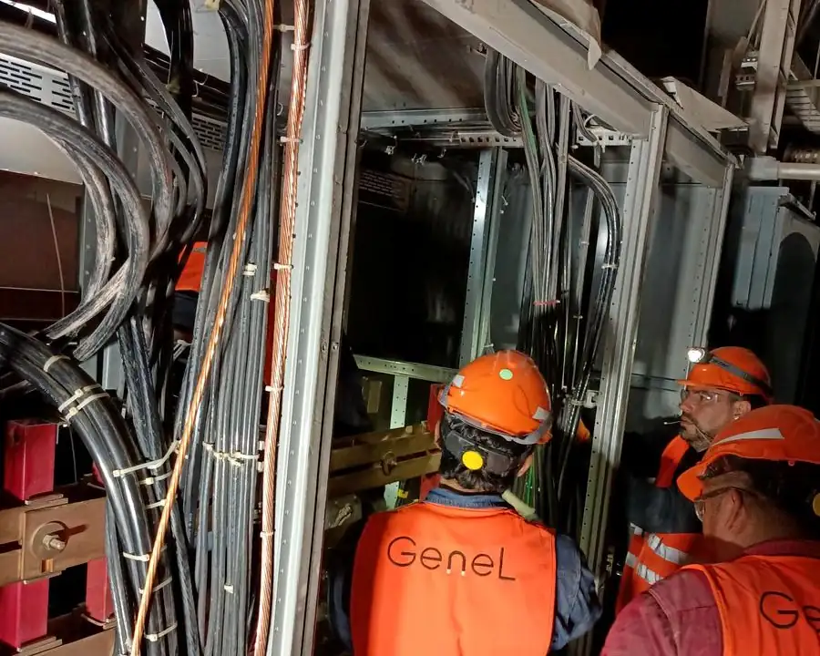 Cuadrilla de GENEL con chalecos de seguridad trabajando en el cableado de un tablero el&eacute;ctrico industrial